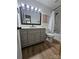Bathroom boasts a gray vanity with a large mirror, toilet, and tub with shower; natural light and wood-look flooring at 11216 Carmel Chace Dr, Charlotte, NC 28226