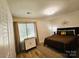 Well-lit bedroom with a comfortable bed, dresser, large window with blinds, and an accent wall at 11216 Carmel Chace Dr, Charlotte, NC 28226