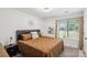 Cozy bedroom showcases a large bed and a sunlit window overlooking the yard at 11216 Carmel Chace Dr, Charlotte, NC 28226