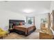 This primary bedroom offers ample natural light, wood floors, and a plush bed with black headboard at 11216 Carmel Chace Dr, Charlotte, NC 28226