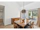 Dining area with a view of the outdoors, featuring hardwood floors and a stylish light fixture at 11216 Carmel Chace Dr, Charlotte, NC 28226