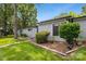 A side view of a charming home with lush landscaping and trees at 11216 Carmel Chace Dr, Charlotte, NC 28226