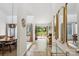 Bright hallway with elegant mirrors that leads to a living area with a fireplace and beautiful view at 11216 Carmel Chace Dr, Charlotte, NC 28226