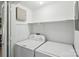 Bright laundry room featuring a washer and dryer, white paint, and a shelf for convenient storage at 11216 Carmel Chace Dr, Charlotte, NC 28226