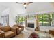 Bright living room featuring a fireplace, large windows with backyard views, and stylish seating at 11216 Carmel Chace Dr, Charlotte, NC 28226