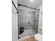 Walk-in shower with glass door, modern fixtures, and a built-in seat and storage niche at 11216 Carmel Chace Dr, Charlotte, NC 28226
