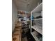 Small storage room with extensive shelving units filled with various stored items and a water heater at 11216 Carmel Chace Dr, Charlotte, NC 28226