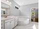 Spa-like bathroom with soaking tub, white marble tile, and elegant fixtures at 11931 The Ramble Dr, Huntersville, NC 28078