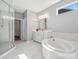 Modern bathroom featuring soaking tub, glass shower, and stylish vanity at 11931 The Ramble Dr, Huntersville, NC 28078