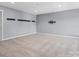Large bonus room with neutral carpet, modern lighting, and mounted shelves and TV mount at 11931 The Ramble Dr, Huntersville, NC 28078