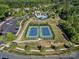 Aerial view of community tennis courts, pool, playground, and clubhouse surrounded by lush landscaping and trees at 11931 The Ramble Dr, Huntersville, NC 28078