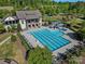 Aerial view of a community pool with slides, lounge chairs, and a clubhouse surrounded by lush landscaping at 11931 The Ramble Dr, Huntersville, NC 28078