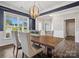 Elegant dining room featuring dark blue accent wall, hardwood floors, and large windows for ample natural light at 11931 The Ramble Dr, Huntersville, NC 28078