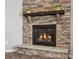 Close-up of a stone fireplace with a wooden mantle and gas logs at 11931 The Ramble Dr, Huntersville, NC 28078