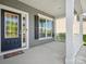 Inviting covered front porch featuring white columns, decorative windows and storm door with decorative glass at 11931 The Ramble Dr, Huntersville, NC 28078