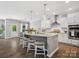 Bright kitchen featuring a large island with seating, modern lighting, and stainless steel appliances at 11931 The Ramble Dr, Huntersville, NC 28078