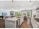 Well-lit kitchen featuring an island with seating, stainless steel appliances, and open view to living area at 11931 The Ramble Dr, Huntersville, NC 28078