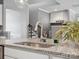 Granite kitchen island with stainless steel sink and faucet, along with decorative accents at 11931 The Ramble Dr, Huntersville, NC 28078