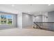Bright and airy living room with large window and dark metal railing leading upstairs at 11931 The Ramble Dr, Huntersville, NC 28078