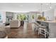 Open-concept living room with hardwood floors, a stone fireplace, and an island with barstool seating at 11931 The Ramble Dr, Huntersville, NC 28078