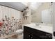 Cozy bathroom features a dark vanity with shelves and a floral shower curtain at 12224 Huntersville Concord Rd, Huntersville, NC 28078