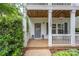 Charming front porch with decorative door, flower pots, and cozy seating area at 12224 Huntersville Concord Rd, Huntersville, NC 28078
