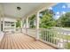 Inviting porch with white pillars, railing and wood flooring overlooking the picturesque outdoors at 12224 Huntersville Concord Rd, Huntersville, NC 28078