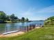 Lake view from backyard with a sandy beach and grassy lawn at 125 Mariner Pointe Ln, Mooresville, NC 28117