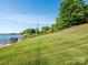 Green backyard lawn slopes down to the lake at 125 Mariner Pointe Ln, Mooresville, NC 28117