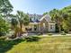 Charming home featuring stone accents, a covered porch, and a beautifully landscaped front yard with mature palm trees at 125 Mariner Pointe Ln, Mooresville, NC 28117