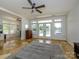 Open living room with fireplace, gray ottoman, tile floor, and access to outdoor lake view at 125 Mariner Pointe Ln, Mooresville, NC 28117