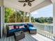 Covered patio with blue cushioned seating, overhead fan, and a view of the surrounding trees and lake at 125 Mariner Pointe Ln, Mooresville, NC 28117