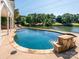 Backyard pool with stone accents overlooking a calm lake surrounded by trees at 125 Mariner Pointe Ln, Mooresville, NC 28117