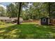 Large backyard featuring a patio, shed, and spacious lawn, ideal for outdoor activities and relaxation at 1427 Worcaster Pl, Charlotte, NC 28211