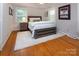 Bedroom with hardwood floors, neutral walls, and a wooden bed frame with a plush rug at 1427 Worcaster Pl, Charlotte, NC 28211