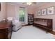 Charming Bedroom with soft pink walls, a crib, and a comfortable glider chair at 1427 Worcaster Pl, Charlotte, NC 28211
