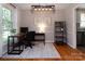 Well-lit home office space with hardwood flooring, modern light fixture, and stylish decor at 1427 Worcaster Pl, Charlotte, NC 28211