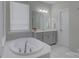Bathroom with a bathtub and vanity with grey cabinetry, and natural light at 15108 Montage Ln, Charlotte, NC 28278