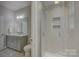 Bathroom featuring a tiled shower with glass door and a vanity with grey cabinetry at 15108 Montage Ln, Charlotte, NC 28278