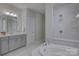 Bright bathroom boasts gray cabinets, soaking tub and shower with tasteful, modern tile work at 15108 Montage Ln, Charlotte, NC 28278