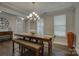 Bright dining room featuring a modern chandelier, stylish table with bench seating, and hardwood flooring at 15108 Montage Ln, Charlotte, NC 28278