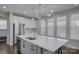 Modern kitchen showcasing a large island, stainless steel appliances, ample natural light, and stylish pendant lighting at 15108 Montage Ln, Charlotte, NC 28278