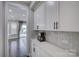 Modern kitchen showcasing sleek white cabinetry, marble backsplash, stainless steel appliances, and stylish countertops at 15108 Montage Ln, Charlotte, NC 28278