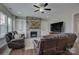 Inviting living room featuring a stone fireplace, built-in shelving, comfortable seating, and hardwood floors at 15108 Montage Ln, Charlotte, NC 28278