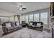 Cozy living room featuring large windows, comfortable seating, a ceiling fan, and an abundance of natural light at 15108 Montage Ln, Charlotte, NC 28278