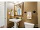 Stylish powder room featuring a pedestal sink, decorative mirror, and coordinated towel racks at 16216 Woolwine Rd, Charlotte, NC 28278