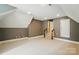 Large bonus room with neutral carpet, stairs, and a modern gray and white paint scheme at 16216 Woolwine Rd, Charlotte, NC 28278