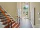 Elegant foyer featuring hardwood floors, a staircase with wooden railing, and a front door with transom window at 16216 Woolwine Rd, Charlotte, NC 28278
