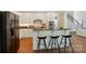 A kitchen featuring an island with barstool seating and stainless steel appliances, adjacent to the living area at 16216 Woolwine Rd, Charlotte, NC 28278