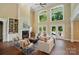 Open living room featuring a fireplace, custom built-ins, soaring windows, and access to the outdoor deck at 16216 Woolwine Rd, Charlotte, NC 28278